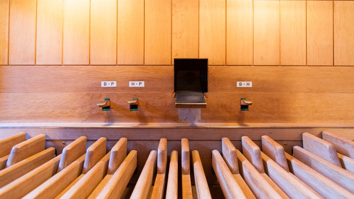 En kirke med træbænke og en lille skranke på væggen.