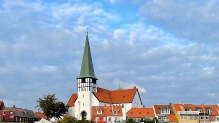 En kystby med kirke og både ved vandet