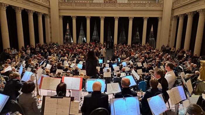 Ein Orchester probt in einem großen Konzertsaal mit Publikum