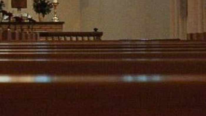 Indre del af kirke med juletree og lysende kandelier