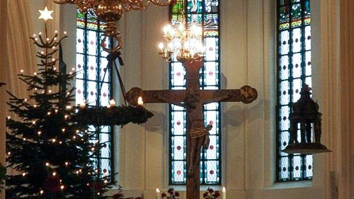 Indre del af kirke med juletree og lysende kandelier