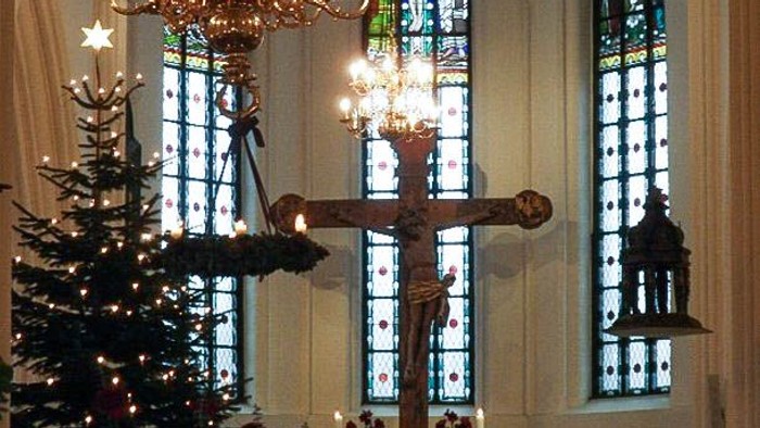 Indre del af kirke med juletree og lysende kandelier