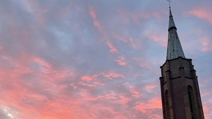 Der Sonnenuntergang über der Stadt mit Kirchtürmen