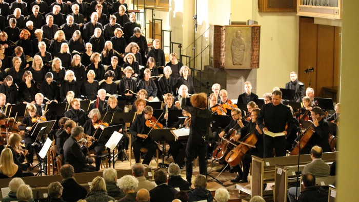 Ein großer Chor und Orchester treten in einer Kirche auf