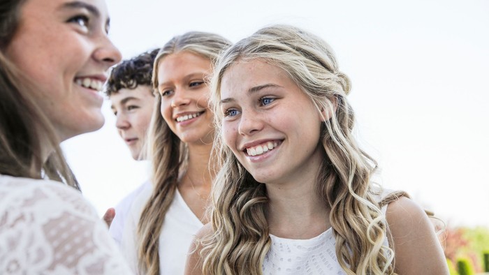 En gruppe unge kvinder smiler og ser glade ud.