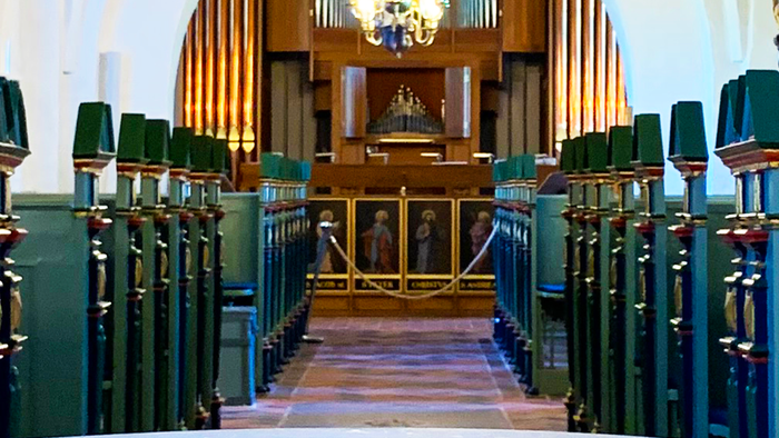 Indre del af kirke med orgel og lysende kandelier