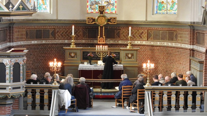 En kirke med troende samlet omkring alteret.