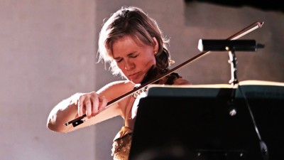 En kvinde, der spiller violin på scenen.