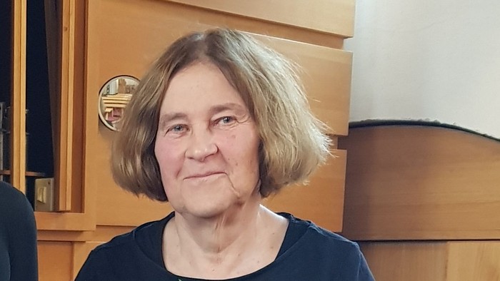 Zwei Frauen in schwarzer Kleidung stehen in einer Kirche.