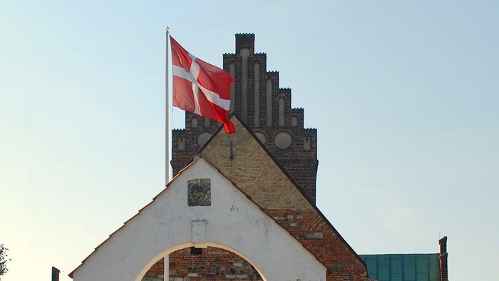 Dansk flag på tårn med blå himmel