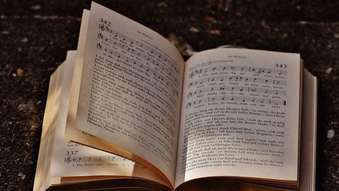 Offenes Buch mit Noten und Text auf dunklem Hintergrund