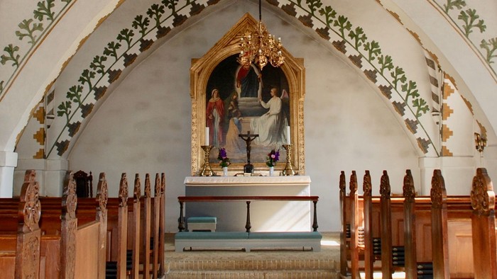 Alter i kirke med malerier og kandlelys