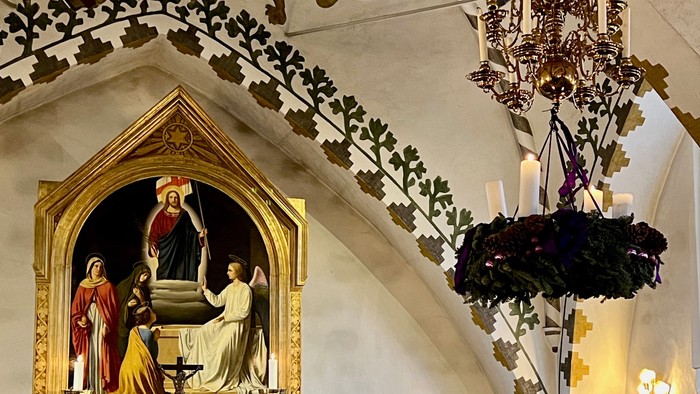 Billedet viser indendørs scene med maleri og juldekorationer.