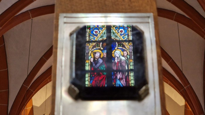 Buntglasfenster in einer Kirche mit religiösen Figuren