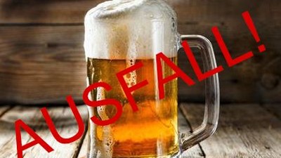 Ein Glas Bier steht auf einem Holztisch mit der Aufschrift "AUSFALL!".