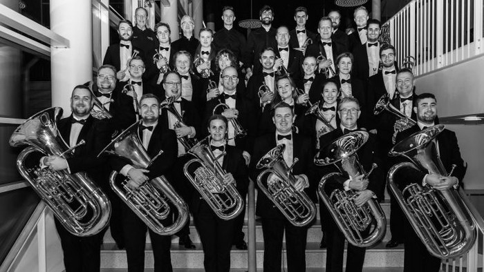 En gruppe musikanere poser med deres instrumenter på en trappe