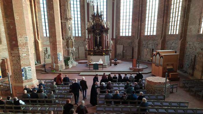 In der Kirche versammeln sich Menschen, um an einer Zeremonie teilzunehmen.