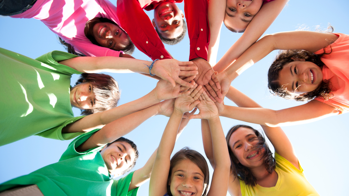 Ein Gruppenfoto von Kindern mit den Händen in der Mitte, beschriftet mit "Thomaskirchene Koln"