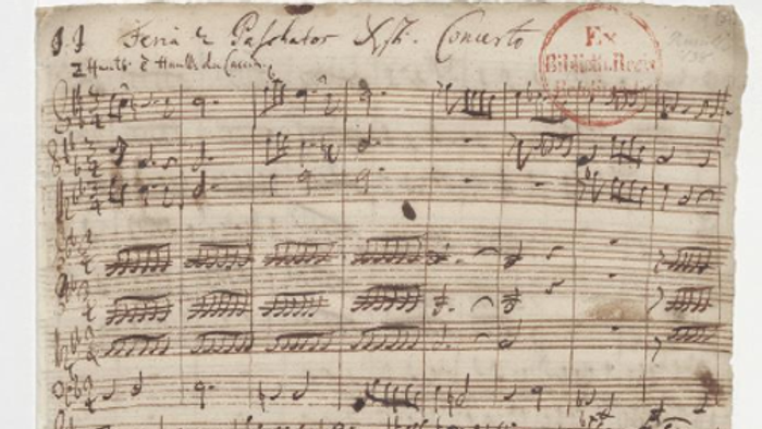 Das Bild zeigt eine handgeschriebene Notenpartitur auf altem Papier.