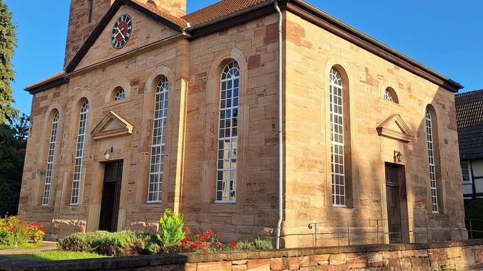 Steinerne Kirche mit hohem Turm und Bogenfenstern.