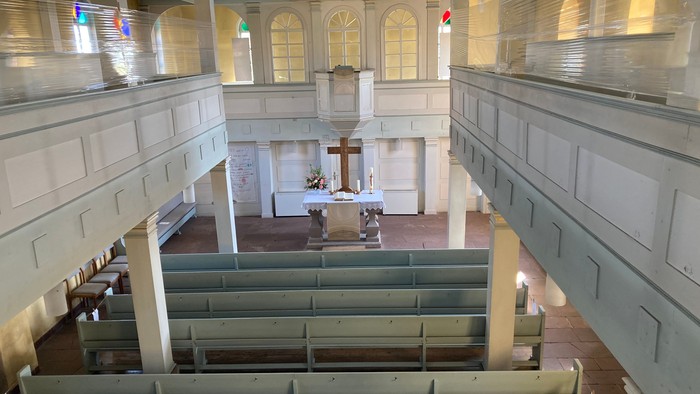 Kircheninneres mit Kirchenbänken und Altar