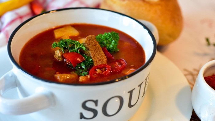 En skål suppe med grøntsager og brød til.