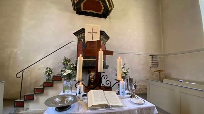 Kleine Kapelle mit Altar, Kerzen und religiösen Gegenständen.