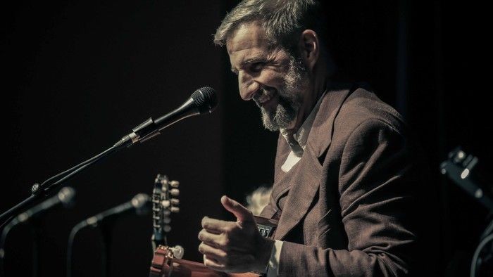 Ein Mann, der Gitarre spielt und in ein Mikrofon singt.