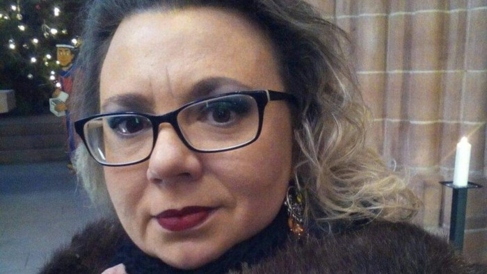 Kvinde med briller og pelsfrakke.