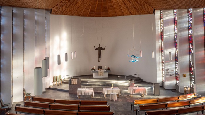 Moderne Kirche mit Holzdecken und weißem Altar