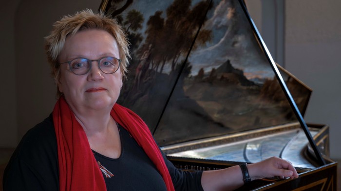 Frau spielt Klavier vor Gemälde