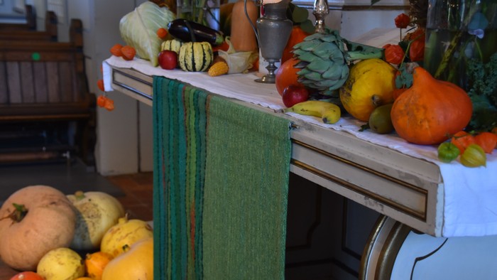 Bunte Kürbisse und Gemüse auf Tisch und Herd