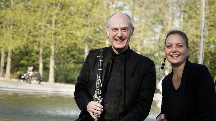 To og kvinde står ved fontæne, han holder klarinet.