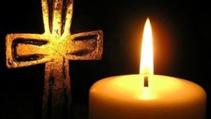 En lysende lyse med en lysende korsformet lysestøbe ved siden