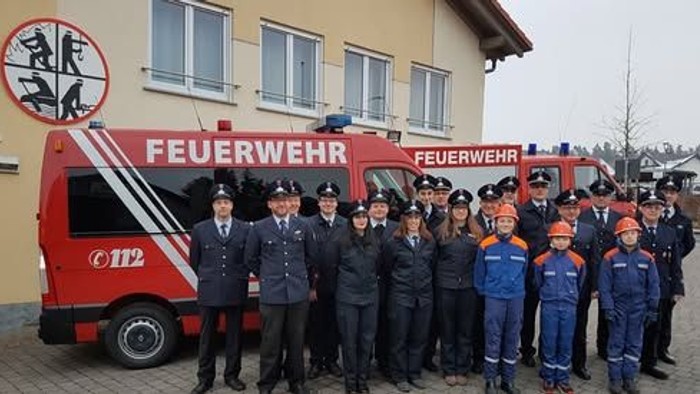 Feuerwehrgruppe vor ihrem Einsatzfahrzeug