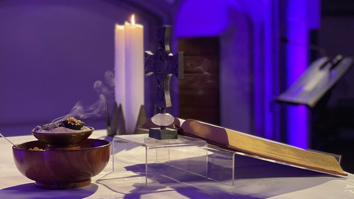 Weißes Tischtuch mit Schale, Kerze und Kreuz