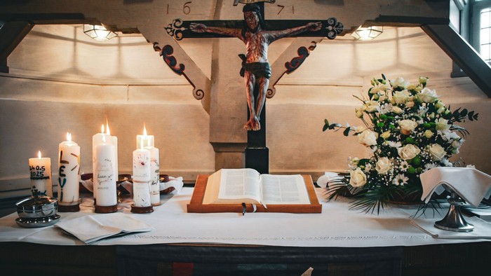Kirchenaltar mit Kruzifix, Kerzen und Blumen