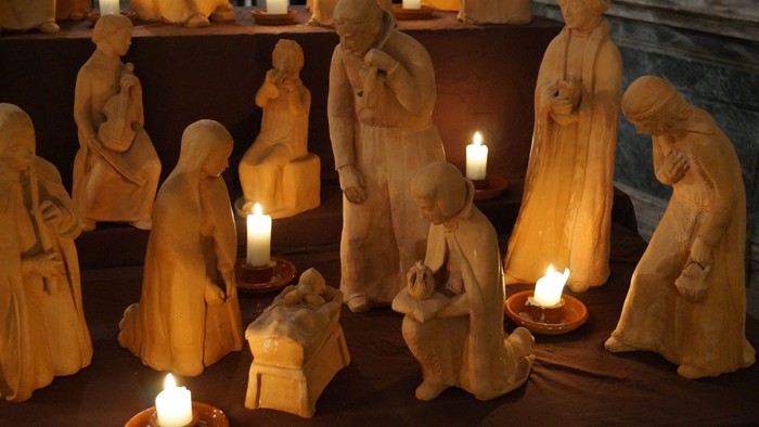 Eine Krippe mit vielen Figuren und Kerzen.