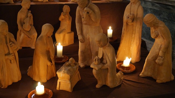 Eine Krippe mit vielen Figuren und Kerzen.