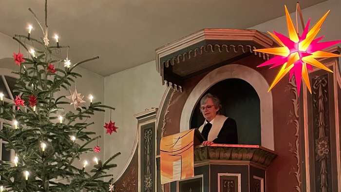 Weihnachtsdekoration in Kirche mit Christbaum und Krippenbild