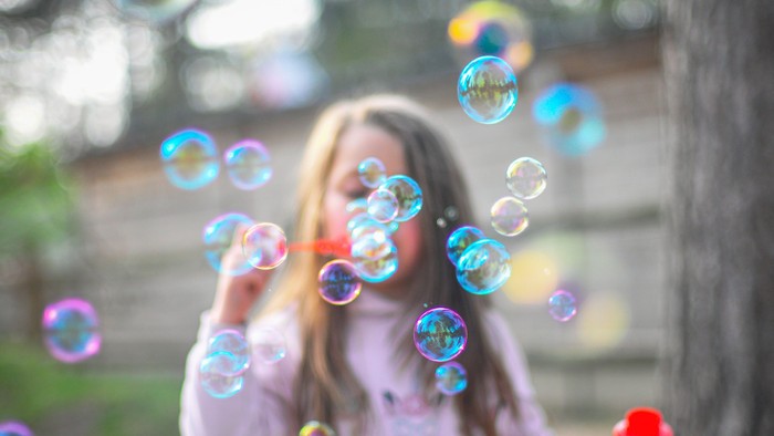 Ein Mädchen bläst Seifenblasen im Freien
