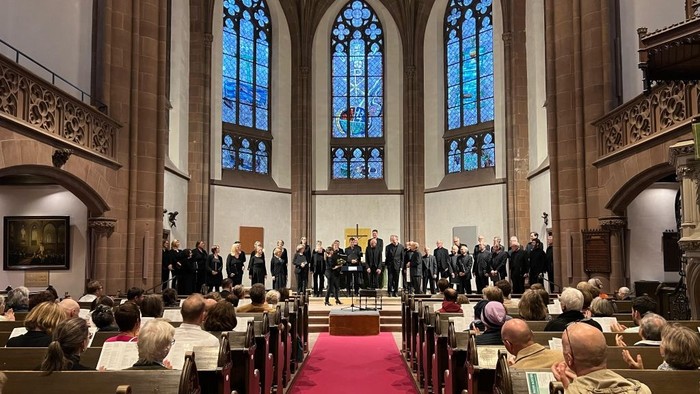 In der Kirche versammelt sich eine Gruppe von Menschen, die an einem Gottesdienst teilnehmen.