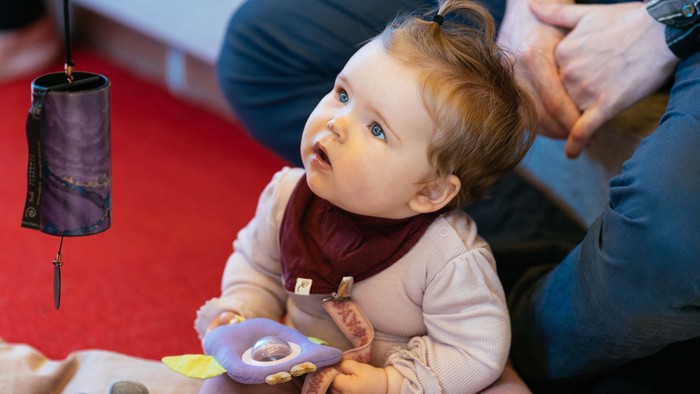Et barn spiller med legetøj på en rød underlag