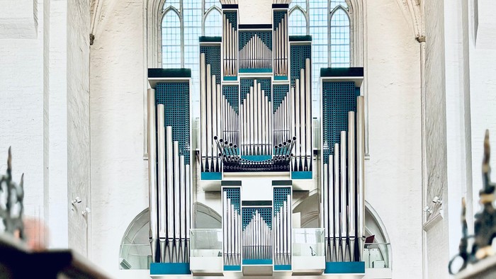 Große Kirchenorgel mit blauen Pfeifen in einem weißen Kircheninneren