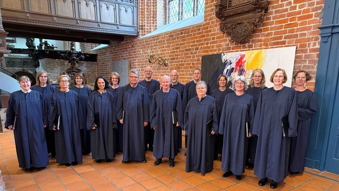 Ein Chor steht in einer Kirche vor einem Backsteingewölbe