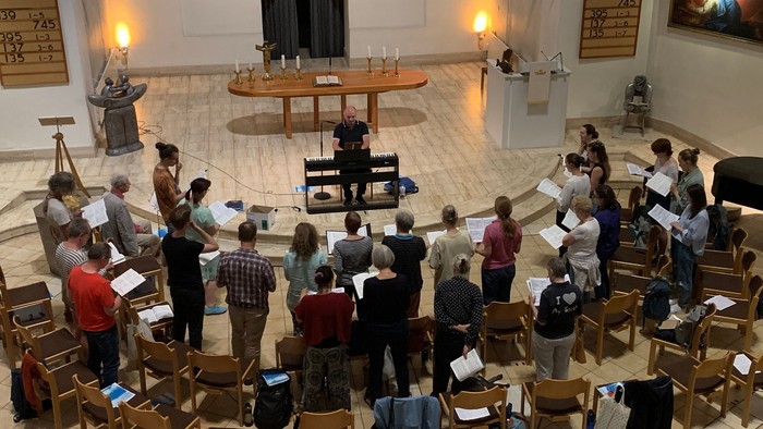 Eine Gruppe von Menschen proben in einer Kirche Musik.