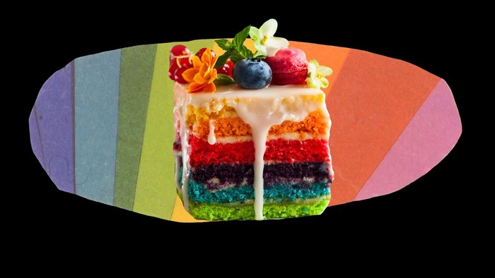 Bunter Regenbogenkuchen mit Früchten und Sahne auf buntem Hintergrund