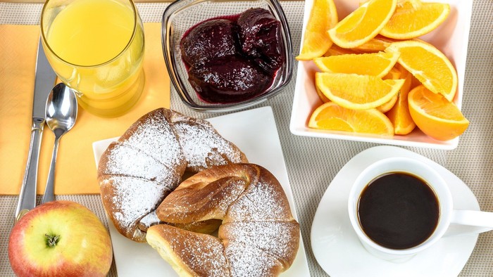 Das Frühstücksbuffet mit Croissant, Obst, Kaffee und Saft