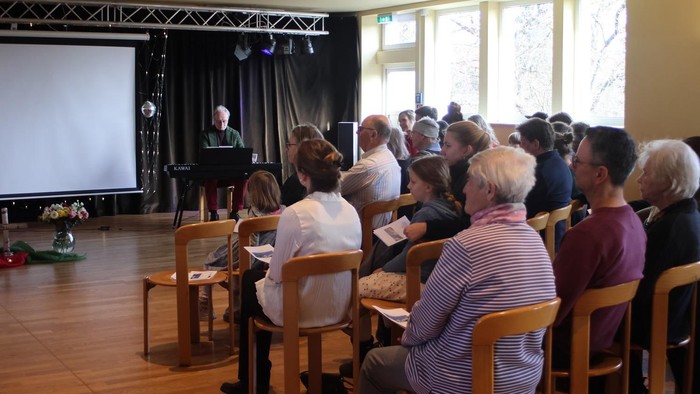 Im Saal der Tanzschule Mierisch sitzen Menschen zu einer Veranstaltung.