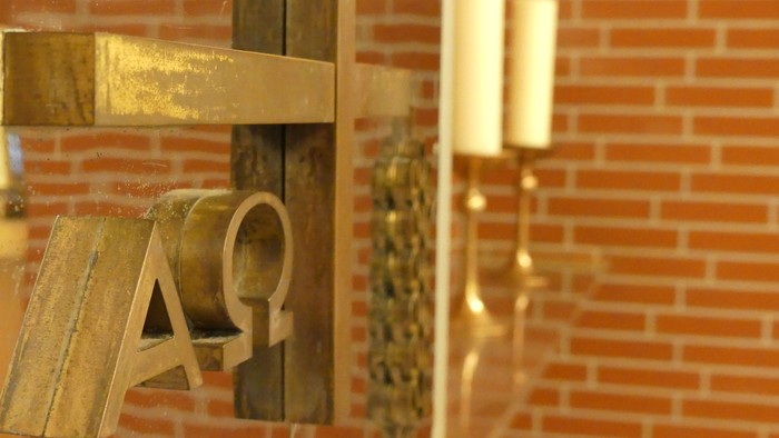 Goldene Buchstaben an Ziegelwand